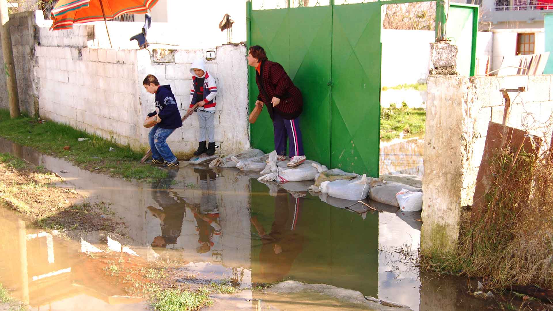 People try to stop a flood with sandbags and bricks.